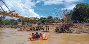 Warga tengah bergotong royong membangun jembatan &quot;karatag&quot; bambu di.Kp. somang. Desa Sukarame, Kec. sajira, sebagai sarana komunikasi.